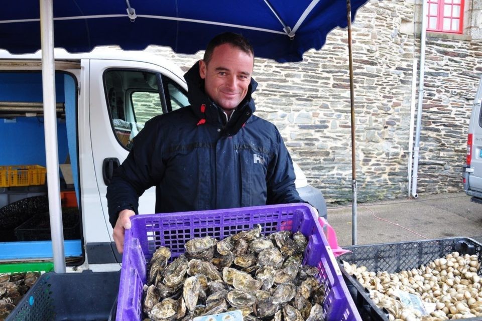 Frédéric Le Guennec présentant un bac d'huîtres sur son étal au marché de Ploërmel